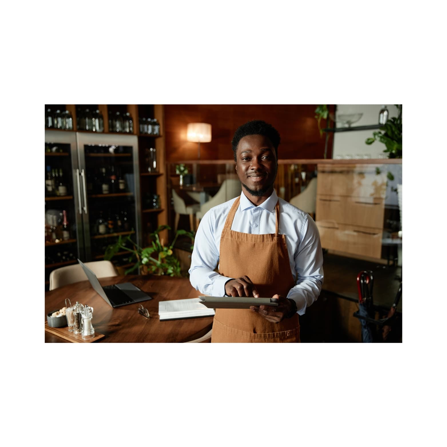 Waiter using Nuru POS on a tablet to take orders